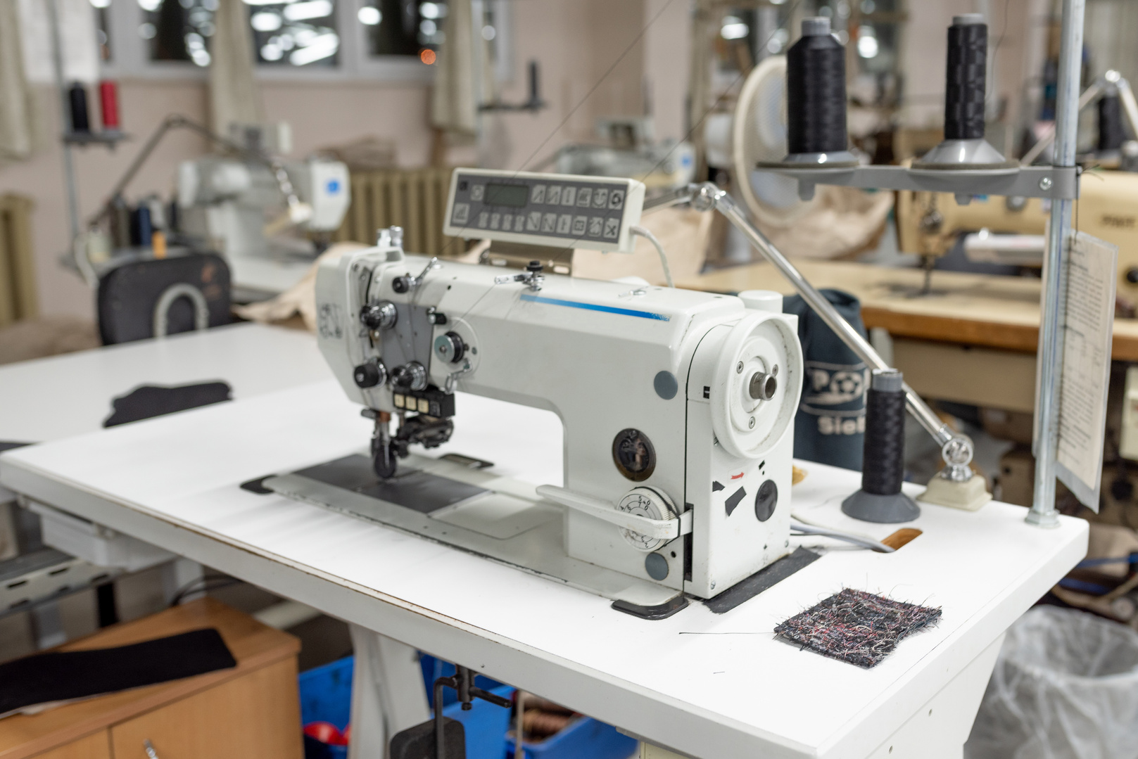 Industrial sewing machine in the work shop. Shoe manufacturing.